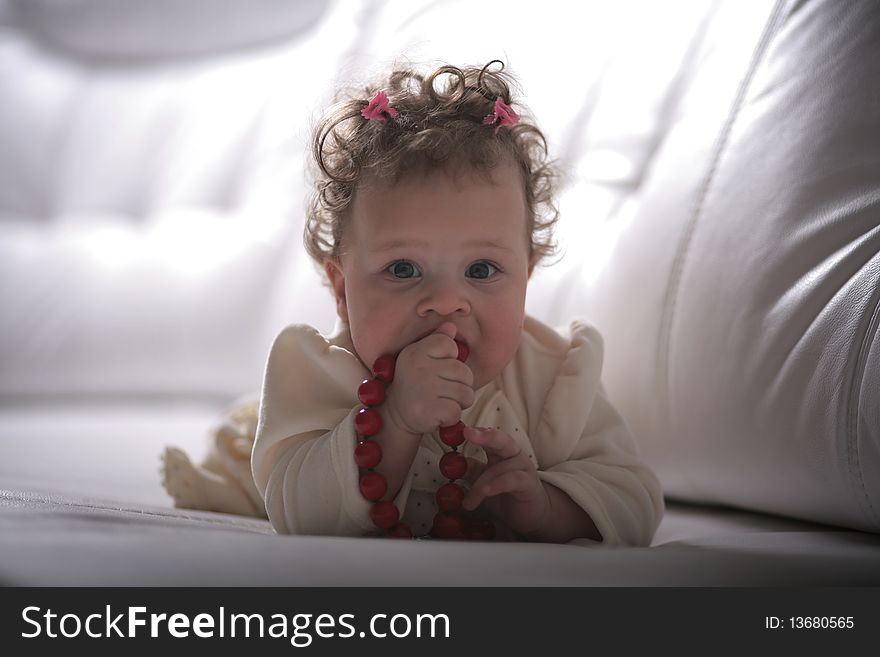 Sweet little baby plays with red mother's beads. Sweet little baby plays with red mother's beads