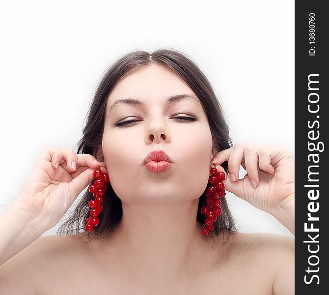 Young girl holds clusters of a red currant as ear rings