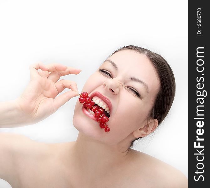 Girl bites a cluster of a ripe red currant. Girl bites a cluster of a ripe red currant