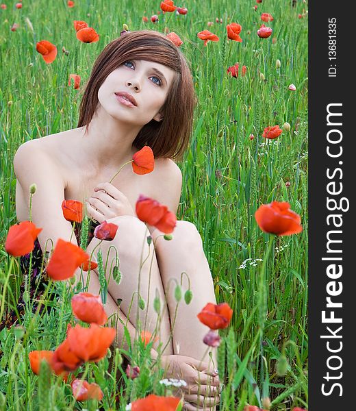 Beautiful girl with long hair posing at poppy meadow. Beautiful girl with long hair posing at poppy meadow