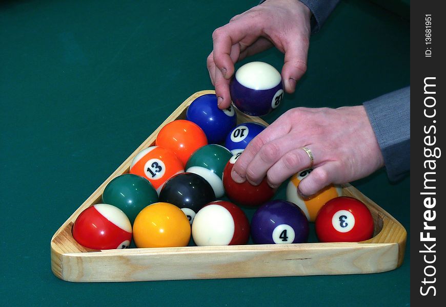 Billiard balls on green table with hands