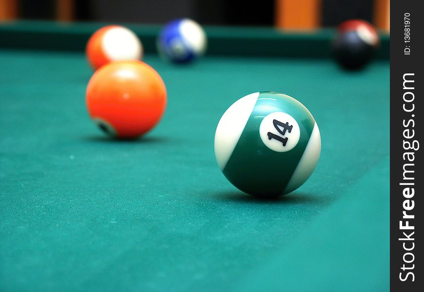Billiard balls on green table - orange and half green