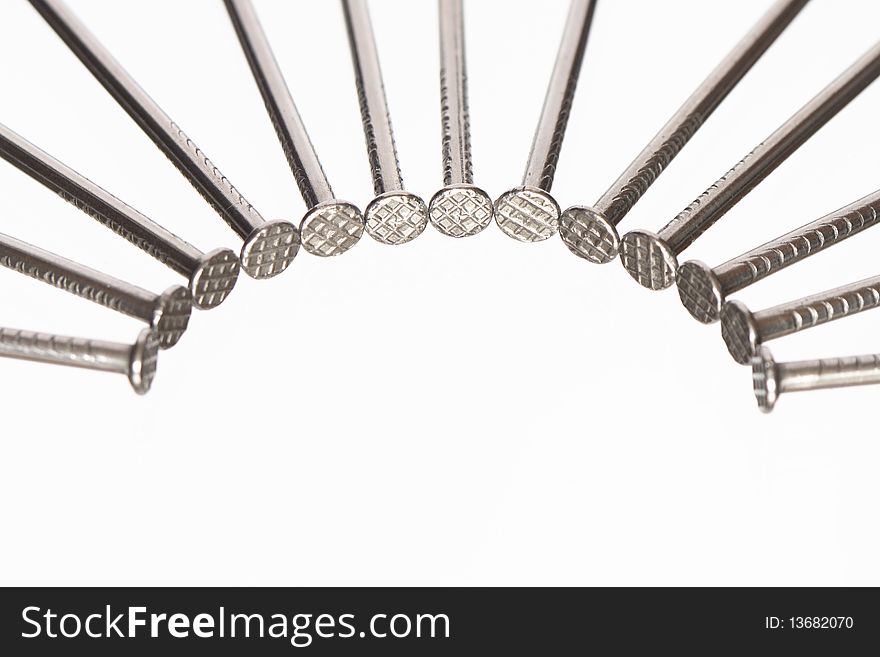 Few nails lying in a row on white background with copy space