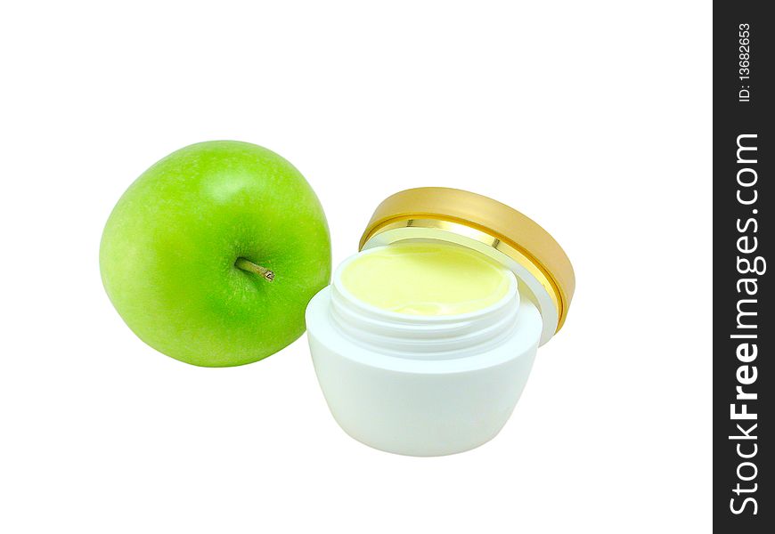 Jar of a fruit cosmetic cream and green apple on a white background close up;