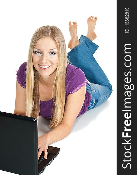 Smiling Caucasian Woman lay on the floor typing on open laptop pc. Smiling Caucasian Woman lay on the floor typing on open laptop pc