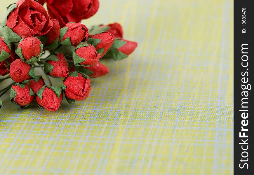 Closeup shot of red paper flowers on green background