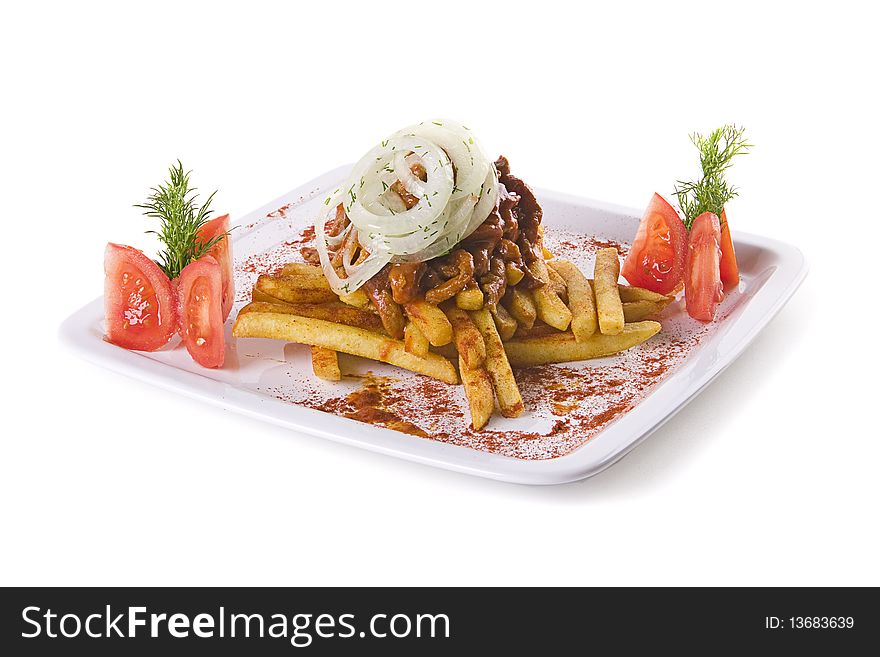 Meat with fries decorated with tomatoes and onion on white plate
