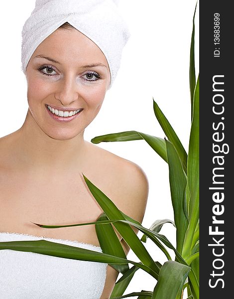 Caucasian woman in towel on head and green plant leaves. Caucasian woman in towel on head and green plant leaves