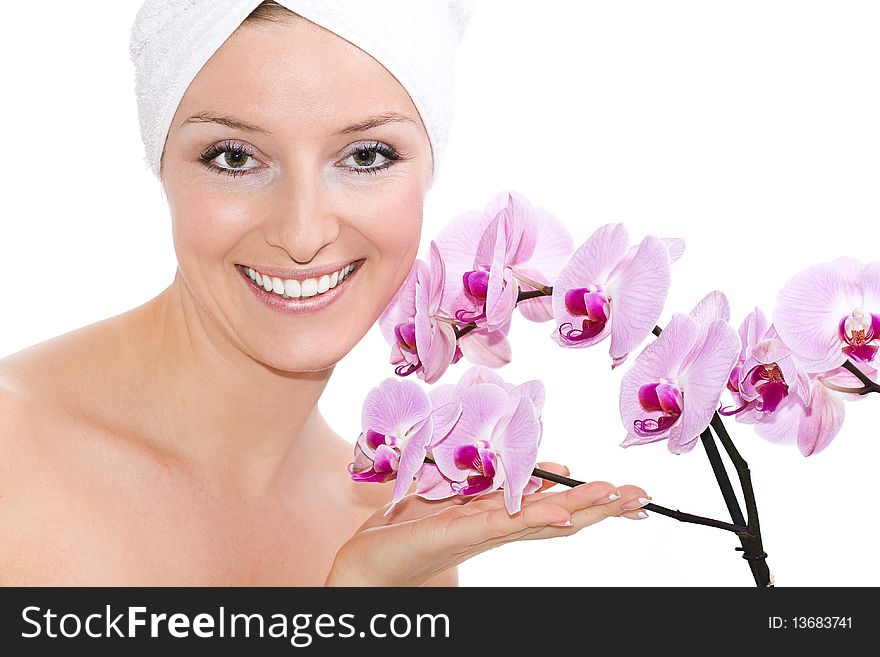 Caucasian woman on white background in towel on head with violet orchid flowers. Caucasian woman on white background in towel on head with violet orchid flowers