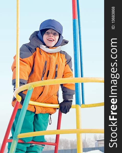 The boy plays a children's playground, cheerfully