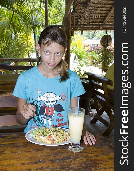 Young girl eating in restaurant