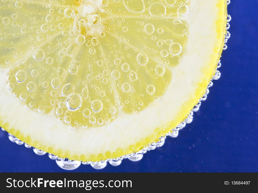Close up on a lemon slice with bubbles.