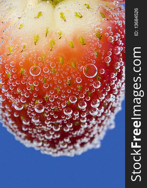 Close up on a strawberry in sparkling water.