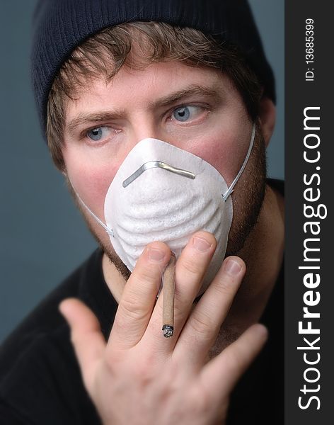 Man smoking cigarette with face mask