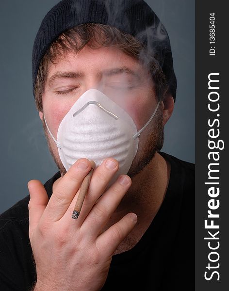 Man smoking cigarette with face mask