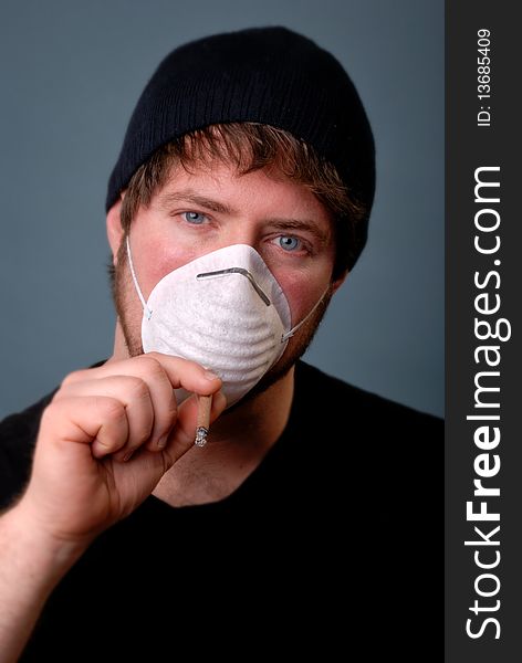 Man smoking cigarette with face mask