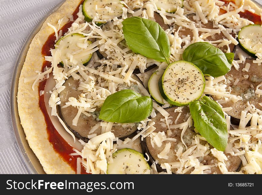 Uncooked pizza with eggplant and zucchini topping