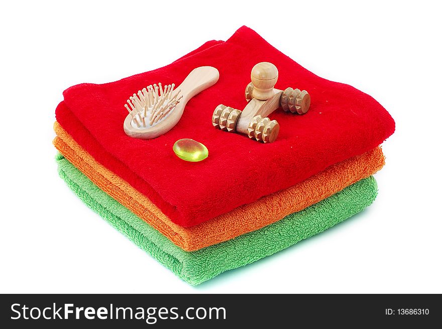 Bright fluffy towels a hairbrush and a masseur on a white background. Bright fluffy towels a hairbrush and a masseur on a white background