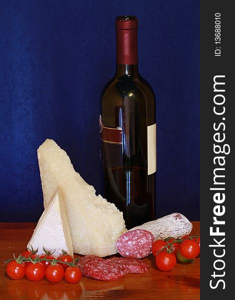 A picture of grana,salami,tomatoes and wine. A picture of grana,salami,tomatoes and wine