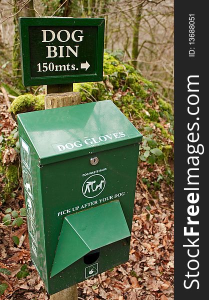 A close up image of a dispenser for gloves used to pick up dog mess set against a countryside setting. A close up image of a dispenser for gloves used to pick up dog mess set against a countryside setting