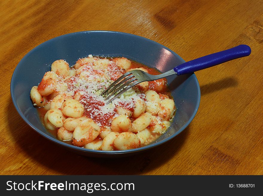 A dish of gnocchi with tomatoes sauce