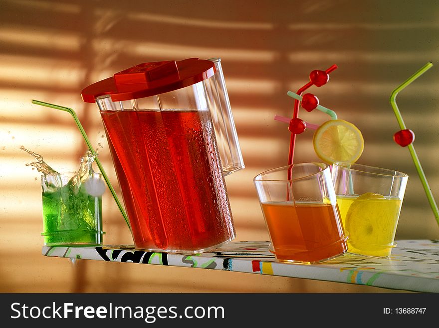 Jar and glasses with colourful drinks and funny straws