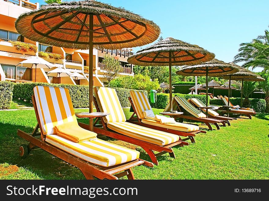 Tropical beach umbrellas and deck-chairs.