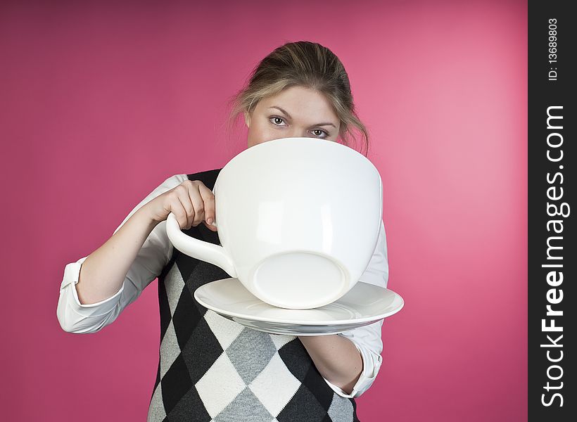 Young girl about to drink from extra large cup, studio