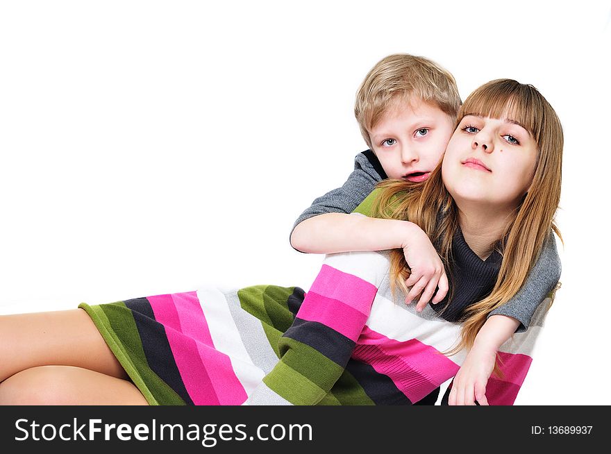 Sweet sister and brother are laying on the white background