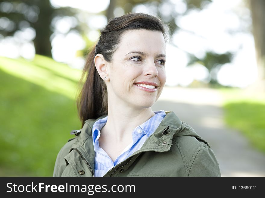 Portrait of a Pretty Young Woman Outdoors in a Park Looking Away From Camera