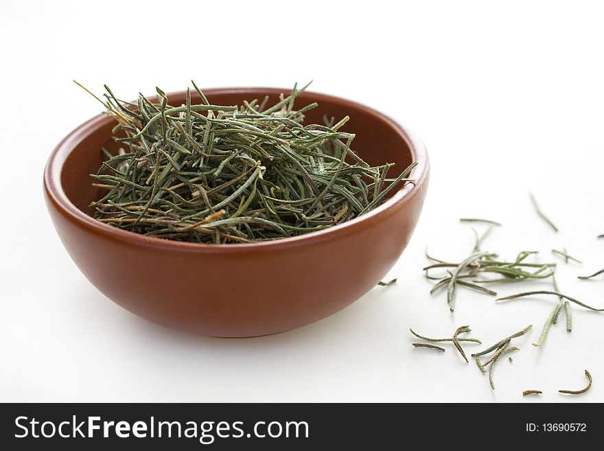 Rosemary in ceramic brown bowl isolated on white background