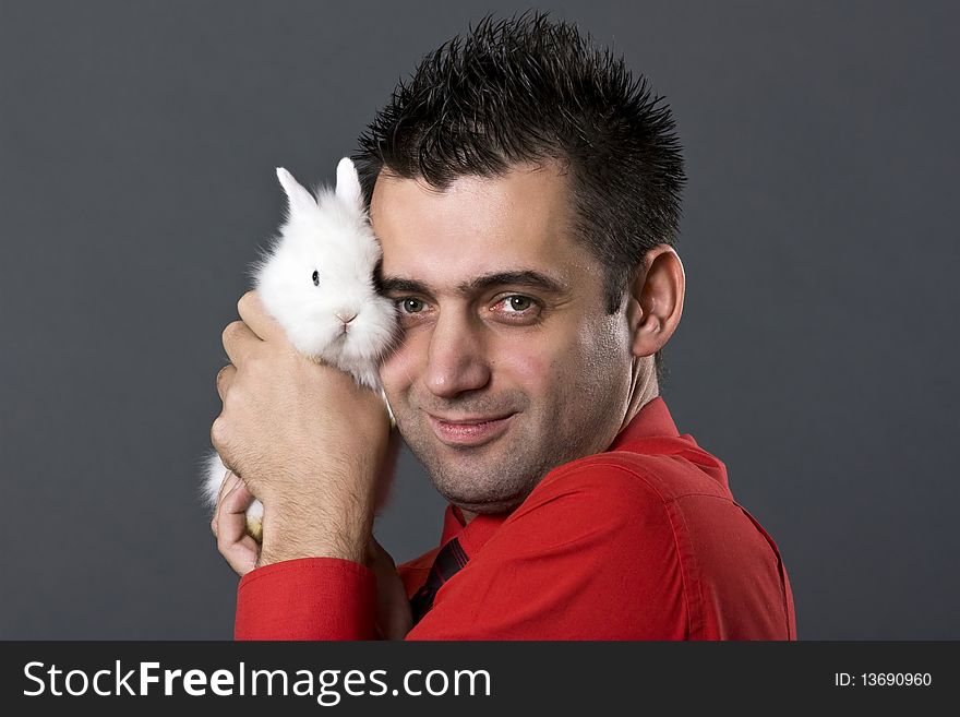 Handsome young man holding baby rabbit. Handsome young man holding baby rabbit