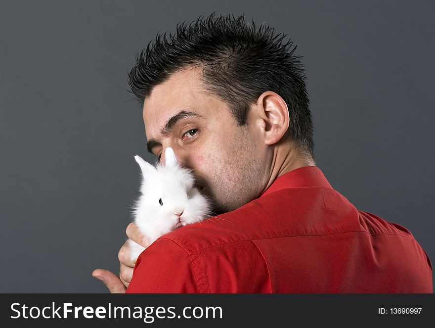 Handsome young man holding baby rabbit. Handsome young man holding baby rabbit