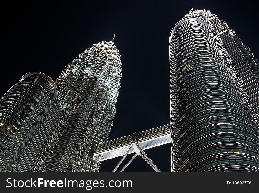 The Petronas Twin Towers by night, photographed from a low angle.