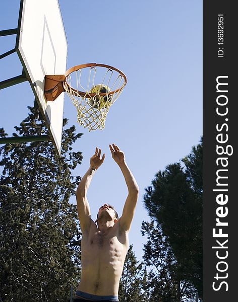 A young man throwing the ball at the basket. A young man throwing the ball at the basket