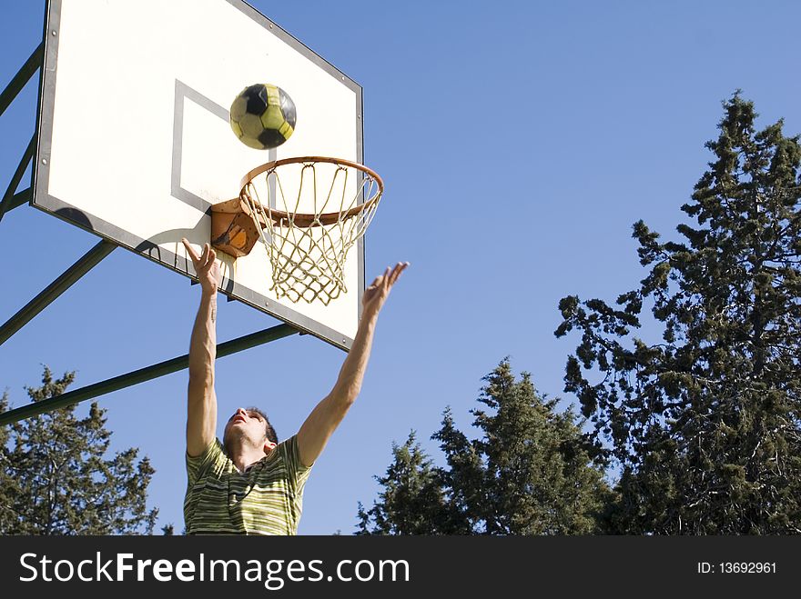 A young man throwing the ball at the basket. A young man throwing the ball at the basket