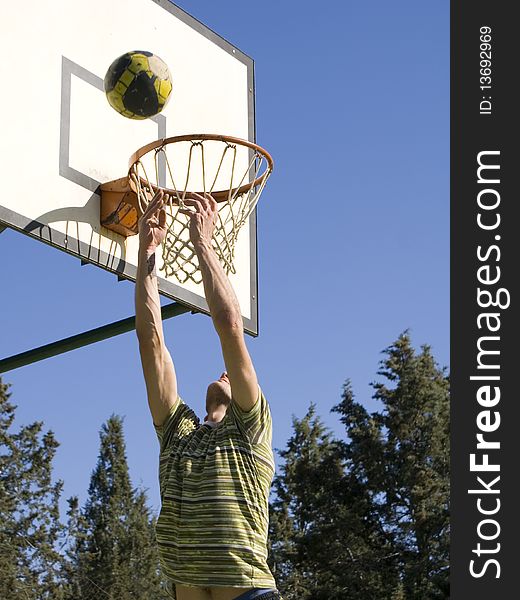 A young man throwing the ball at the basket. A young man throwing the ball at the basket