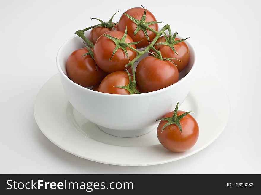 White bowl full of vine tomatoes. White bowl full of vine tomatoes