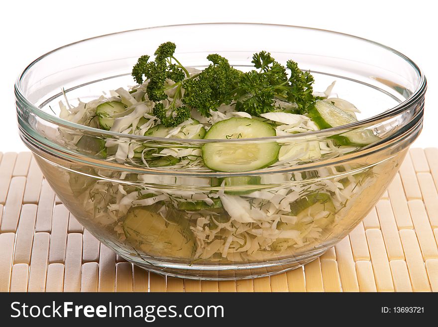 Salad in a glass bowl from cabbage of a cucumber and the fennel, isolated on a white background