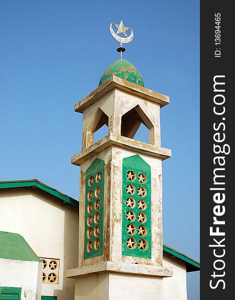 Old mosque with minaret and crescent moon and star finial