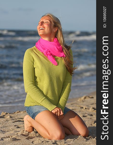 Caucasian blond woman sitting and smiling on beach. Caucasian blond woman sitting and smiling on beach