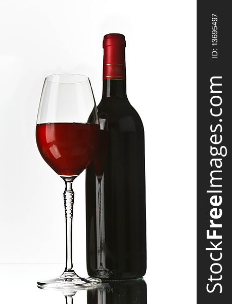 Red wine glass and bottle on white