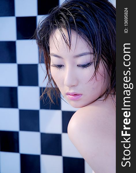 Asian girl with checkered background in bathroom with soft sensual look. Asian girl with checkered background in bathroom with soft sensual look