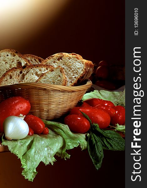 Slices of bread in basket with tomatoes, in country style