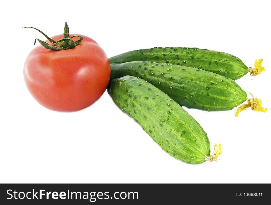 Red tomatoes and three green cucumber on a white background. Red tomatoes and three green cucumber on a white background