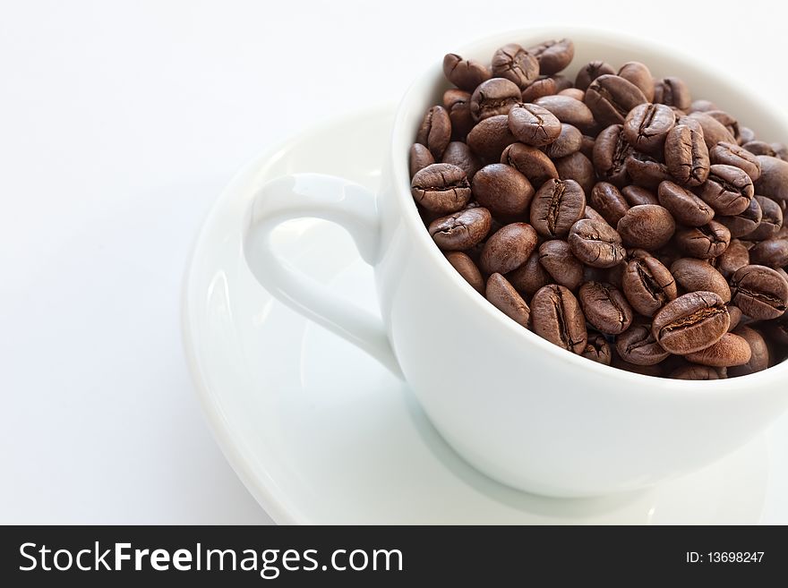 Coffee cup with coffee beans on white background