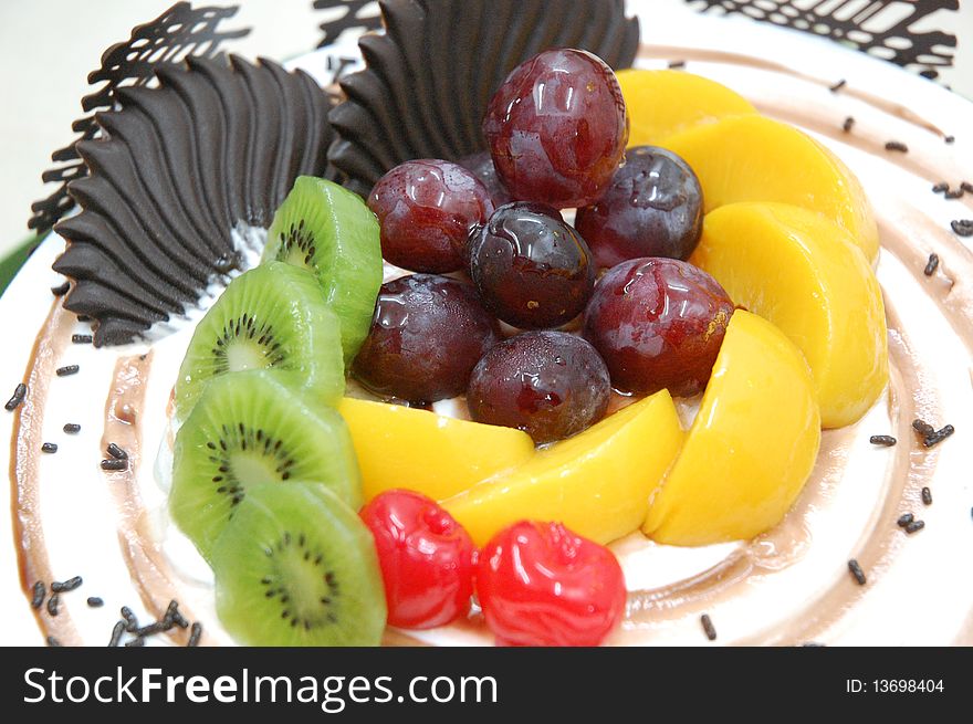A birthday cake with fruit display at the top