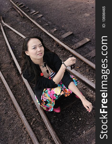 Asian girl sit on rail