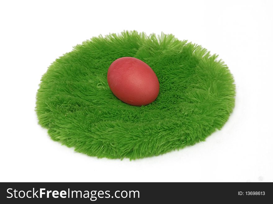 Red Easter egg on a green grass