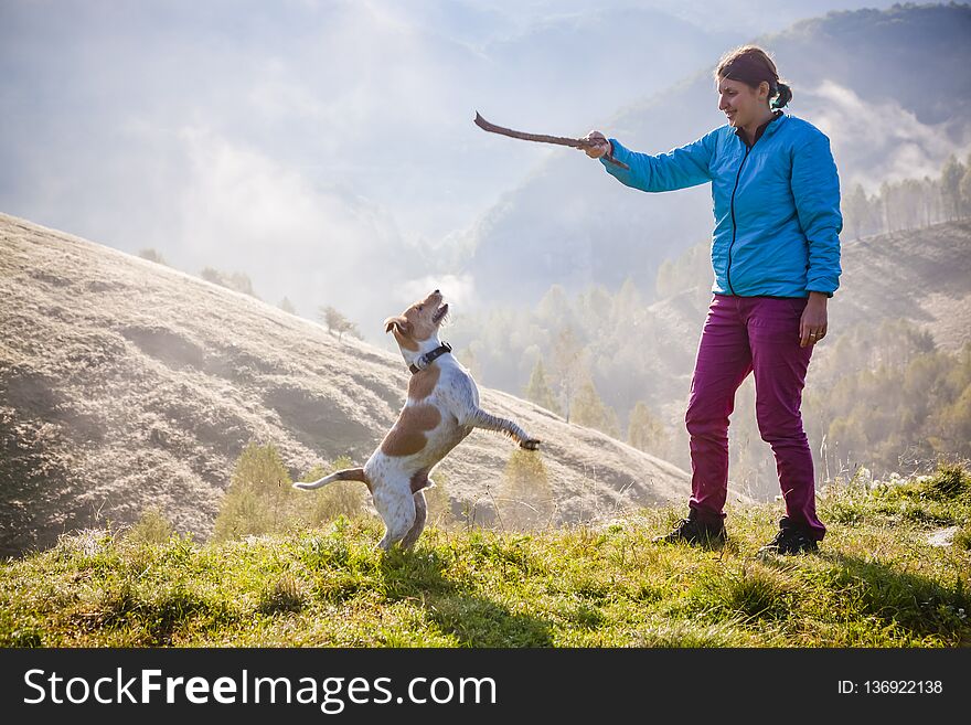 Woman Playing With Her Dog In Beautiful Mountain Scenery In Spring